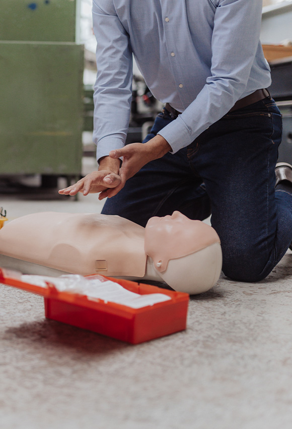 person practicing CPR techniques on a training dummy with a first aid kit nearby focusing on essential lifesaving skills and 10 key steps for emergency response