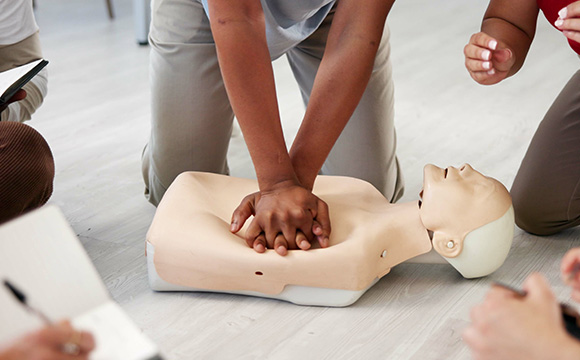 person performing CPR on dummy during training session group learning essential lifesaving techniques